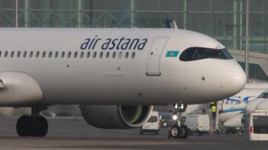 ALMATY, KAZAKHSTAN - 27 Haziran 2024: Yolcu uçağı Airbus A321, Air Astana EI-KDG pistte, Almaty havaalanından kalkış, yan görüş. Seyahat kavramı