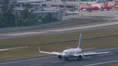 PHUKET, THAILAND - ŞUBAT 03, 2023: Jet yolcu uçağı pistte. Boeing 737, UP-B3726 Phuket havaalanına indikten sonra fren yapıyor. Uçak geliyor.