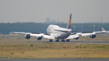 FRANKFURT AM MAIN, Almanya - 20 Temmuz 2017: Lufthansa 'nın Boeing 747' si Frankfurt havaalanındaki piste iniyor. Jumbo jet geliyor, dikiz aynasından. Büyük uçak fren yapıyor, spoiler veriyor.