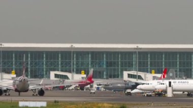 ALMATY, KAZAKHSTAN - 27 Haziran 2024: Airliner Airbus A320, EI-KBN of Fly Arystan Almaty havaalanında taksicilik. Terminalde bir sürü uçak var, apron. Yolcu uçağı. Seyahat kavramı