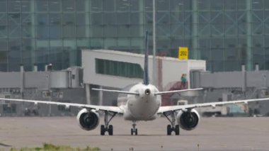 Uçak terminale iniyor. Yolcu uçağı geldi. Taksideki jet uçağının görüntüsü. Beneklenme