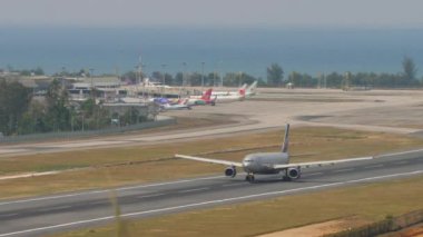 PHUKET, THAILAND - 13 Şubat 2023: Yolcu uçağı Airbus A330, RA-73785 Phuket havaalanından havalanır. Havaalanı manzarası