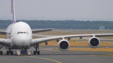 FRANKFURT AM MAIN, ALMANY - 20 Temmuz 2017 Tay Havayolları 'nın dev Airbus' u A380. Çekici, Frankfurt am Main Havaalanı pistinde uçak çekiyor.
