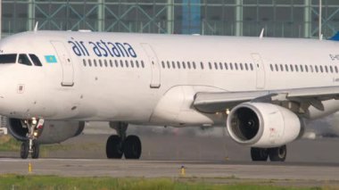 ALMATY, KAZAKHSTAN - 27 Haziran 2024: Airbus A321, Air Astana 'dan EI-KDA, Almaty Havaalanı' ndaki pistte dönüyor, yan görüş, orta çekim