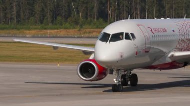 MOSCOW, Rusya Federasyonu - 31 Temmuz 2021: Orta atış, Sukhoi Superjet 100, RA-89114 Rossiya taksiyolunda. Yolcu uçağı kalkıyor. Avia trafiği. Seyahat kavramı