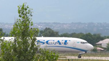 ALMATY, KAZAKHSTAN - 24 Haziran 2024: Boeing 737 sefer sayılı uçak, SCAT Havayolları 'ndan UP-B3739 Almaty havaalanında taksicilik yapıyor. Taksiyoldaki uçak, yan görüş. Beneklenme