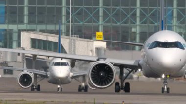 ALMATY, KAZAKHSTAN - 27 Haziran 2024: Airbus A321, Air Astana taksicilik EI-KGK, ön görüş. Embraer E190, Astana Havayolları 'ndan El-KHE. Almaty Uluslararası Havaalanı, Kazakistan 'a trafik