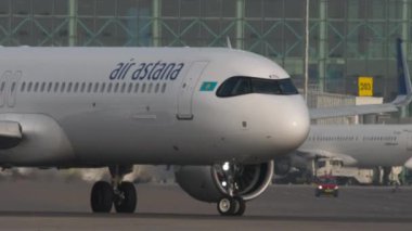 ALMATY, KAZAKHSTAN - 27 Haziran 2024: Airplane Airbus A321, Air Astana 'nın El-KDG' si Almaty havaalanı pistinde, yan görüş. Seyahat kavramı