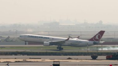 BANGKOK, THAILAND - 01 Mart 2023: Airplane Airbus A330, TC-JOI, Suvarnabhumi Havaalanı pistine iniyor, yan görüş. Uçak geliyor, fren yapıyor. Spoiler hazır..