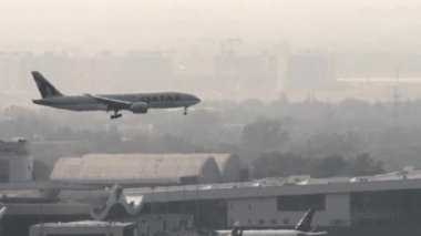 ALMATY, KAZAKHSTAN - 26 Haziran 2024: Katar 'ın Kargo Boeing 777' si Almaty havaalanına iniyor, yan görüş, uzak çekim. Geniş gövdeli uçak alçalıyor.