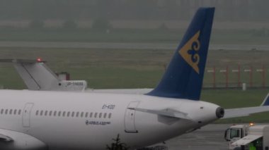 ALMATY, KAZAKHSTAN - 12 Mayıs 2024: Yakovlev Yak-40, KazAirJet 'ten UP-Y4033 yağmurlu bir günde taksicilik. Yağmurlu havada havaalanı. Üç motorlu turbo jet yolcu uçağı