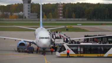 MOSCOW, Rusya Federasyonu - Ekim 02, 2022: Boeing 737 Pobeda yolcu uçağına binen yolcular. Binmek için iki tane seyyar merdiven rampası kullanın.