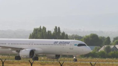 ALMATY, KAZAKHSTAN - 24 Haziran 2024: Yolcu uçağı Airbus A321, Air Astana EI-KGD Almaty havaalanında taksicilik yapıyor, yan görüş. Seyahat kavramı