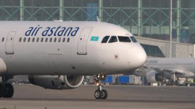 ALMATY, KAZAKHSTAN - 27 Haziran 2024: Ticari jet uçağı Airbus A321, Almaty Havaalanı pistinde EI-KDA, yan görüş, orta çekim. Uçak kalkış için hazır. Önlük, havaalanı terminali