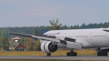 MOSCOW, Rusya Federasyonu - 29 Temmuz 2021: Nordwind Havayollarının Boeing 777 'si yavaşlıyor. Motorlar tersine döndü. Jet geliyor. Spoiler hazır.