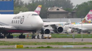 ALMATY, KAZAKHSTAN - 11 Mayıs 2024: Boeing 747, SF Havayolları 'ndan B-2423 Almaty havaalanında çekici. Traktör kargo jumbo jetini çekiyor..