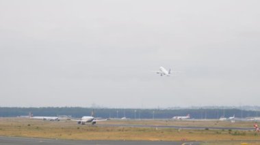FRANKFURT AM MAIN, Almanya - 20 Temmuz 2017: Airbus A320, Lufthansa indikten sonra fren yapıyor. Boeing 777 United havalanıyor.