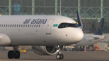 ALMATY, KAZAKHSTAN - 27 Haziran 2024: Airbus A321, Air Astana 'dan EI-KGC Almaty Havaalanında taksicilik, yan görüş. Havaalanında uçak var.