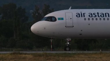 ALMATY, KAZAKHSTAN - 24 Haziran 2024: Yolcu uçağı Airbus 321neo, Air Astana EI-KGF Almaty havaalanı pistinde, yan görüş. Uçak kalkıyor. Uçak havalandı.