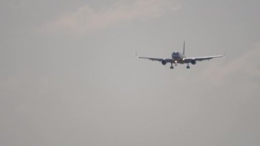 Uçak inişe geçiyor, ön manzara. İniş yapan bir jet uçağı görüntüsü geliyor. Mavi gökyüzünde bir uçak. Seyahat kavramı