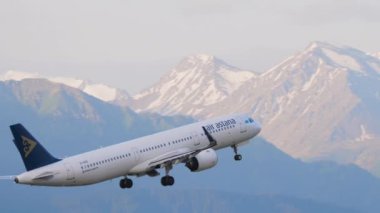 ALMATY, KAZAKHSTAN - 24 Haziran 2024: Airbus A321-271N, Air Astana EI-KDD Almaty havaalanından havalanır. Arka planda dağların güzel manzarası