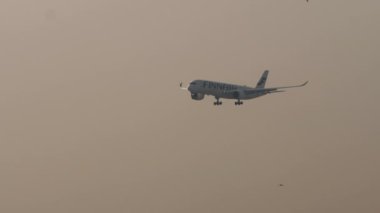 BANGKOK, THAILAND - Mart 01, 2023, Bangkok, Suvarnabhumi Havaalanı 'na inmeden önce Finnair Airbus A350 yaklaşıyor. Uçak geliyor, yan görüş.