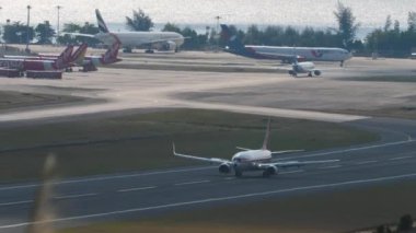 PHUKET, THAILAND - 19 Şubat 2023: Malezya Havayolları 'ndan Boeing 737 Phuket Havaalanı' na iniş ve frenleme. Spoiler verin. Gözetleme. Deniz kenarında bir havaalanı.