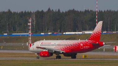 MOSCOW, Rusya Federasyonu - 31 Temmuz 2021: Plane Sukhoi Superjet 100, RA-89114 Rossiya taksisi, yan görüş. Taksideki ya da pistteki yolcu uçağı. Avia trafiği. Seyahat kavramı