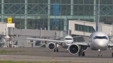 ALMATY, KAZAKHSTAN - 27 Haziran 2024: Airbus A321, Air Astana taksicilik EI-KGK. Jet Embraer E190, Astana Havayolları 'ndan El-KHE. Almaty Uluslararası Havaalanı, Kazakistan 'a trafik