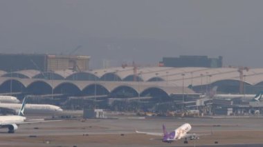 HONG KONG - 10 Kasım 2019: Airbus A320, HS-TXQ, Hong Kong havaalanından kalkış. Yolcu uçağı kalkıyor. Uçak kalkıyor, uzak çekim, yan görüş. Yoğun havaalanı, trafik