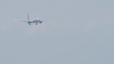 Uçak iniş yapıyor, yan görüş. Tanımlanamayan bir üniforması olan jet uçağı iniyor, geliyor, düşük ihtimal. Mavi gökyüzünde uçaklar