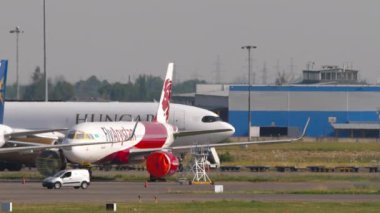 ALMATY, KAZAKHSTAN - 25 Haziran 2024: Airbus A330 Macar Hava Taşımacılığı. Havaalanında geniş gövdeli nakliye uçakları, yan görüş. Uçan Arystan terminale park ediyor.