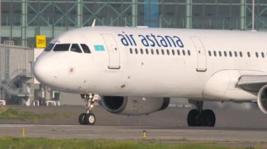 ALMATY, KAZAKHSTAN - 27 Haziran 2024: Airbus A321, Air Astana taksicilik EI-KDA, Almaty Havaalanı 'ndaki pistte dönüyor. Hava sahasında uçak, orta atış.
