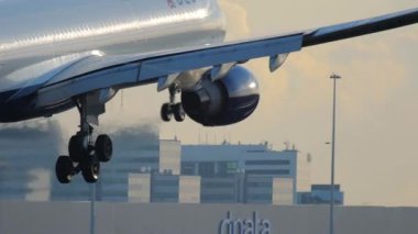 AMSTERDAM, NETHERLANDS - 25 Temmuz 2017: çekimler, Delta Air 'in Airbus A330 uçağı alacakaranlıkta alacakaranlıkta iniyor, günbatımı aydınlık bir piste. Uçak geliyor. Seyahat kavramı