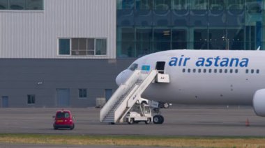 ALMATY, KAZAKHSTAN - 25 Haziran 2024: Boeing 767, Air Astana EI-KEB havaalanında. Uçak merdiveni havaalanındaki uçağa bağlı.
