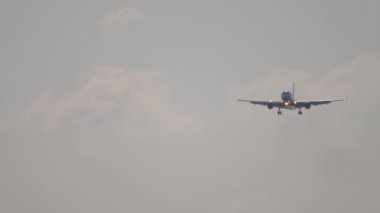 İniş yapan bir uçağın ön görüntüsü. Tanımlanamayan bir üniformayla gelen bir jet uçağı. Mavi gökyüzünde uçaklar