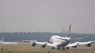 FRANKFURT AM MAIN, ALMANY - 20 Temmuz 2017: Boeing 747, Lufthansa 'lı D-ABYP Frankfurt havaalanındaki pistte yavaşlıyor. Jumbo jet geliyor, dikiz aynasından. Uçak indikten sonra fren yapıyor.