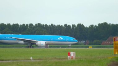 AMSTERDAM, NETHERLANDS - 24 Temmuz 2017: Boeing 737, KLM Airlines 'ın PH-BXT' si havalandı. Boeing 777 KLM arkadan geliyor. Paralel olarak uçak iniyor.