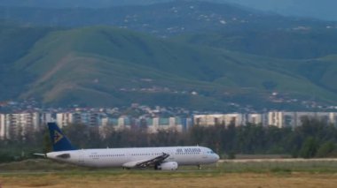 ALMATY, KAZAKHSTAN - 24 Haziran 2024: Airbus 321, Air Astana EI-KDA Almaty havaalanından havalanır. Uçak ve dağ arka planı. Uçuş kalkışı