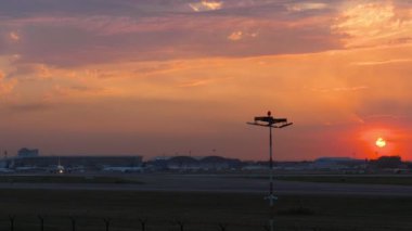Havaalanı üzerindeki inanılmaz altın gün batımının sinematik görüntüleri. Terminal, önlük ve pist panoramik görünümü