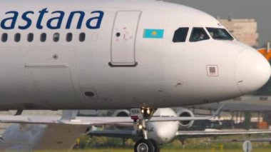 ALMATY, KAZAKHSTAN - 27 Haziran 2024: Kapanış, Airbus A321, Air Astana EI-KDA Almaty Havaalanı pistinde. Uçak kalkış için hazır. Önlük, havaalanı terminali