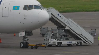 ALMATY, KAZAKHSTAN - 10 Mayıs 2024: Boeing 767, Air Astana 'dan EI-KEC. Uçağa binen yolcular. Merdivenlerdeki adamlar.