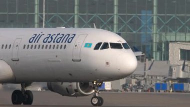 ALMATY, KAZAKHSTAN - 27 Haziran 2024: Airbus A321, Almaty Havaalanında taksicilik yapan Air Astana 'dan EI-KDA. Hava sahasında uçak, orta atış.