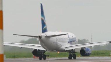 ALMATY, KAZAKHSTAN - 12 Mayıs 2024: Uçak Sukhoi Superjet 100, Yakutia Havayolları RA-89037 Almaty Havaalanı pistinde. Yolcu jeti kalkıyor. Uçak geliyor.