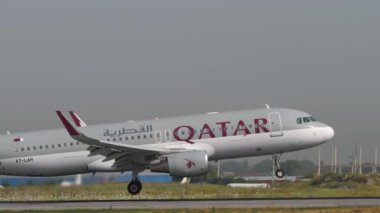 ALMATY, KAZAKHSTAN - 27 Haziran 2024: yan görüş, Airbus A320, Katar Havayolları 'nın A7-LAH inişi, Almaty Havaalanı pistinde frenleme. Spoiler verin. Seyahat kavramı