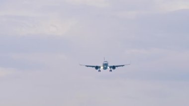 Tanımlanamayan üniformalı bir jet uçağı iniş yapmak üzere, uzak çekim, ön görüş. Seyahat kavramı