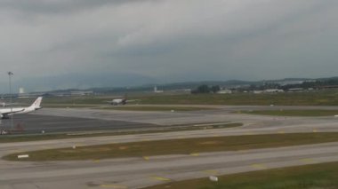 KUALA LUMPUR, MALAYSIA - 15 HAZİRAN 2025: kalkış sırasında uçak penceresinden seyahat videosu. Uçak kanadı ve uçak pisti yolcuların gözü lombozdan içeri bakıyor. 4k görüntü