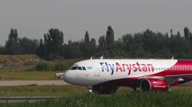 ALMATY, KAZAKHSTAN - 25 Haziran 2024: Ticari jet uçağı Airbus A320, FlyArystan EI-KBV Almaty havaalanında taksicilik, yan görüş. Taksiyoldaki uçaklar