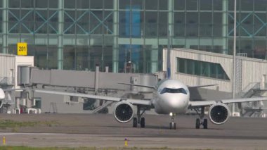 ALMATY, KAZAKHSTAN - 27 Haziran 2024: Air Astana taksicilik Airbus A321. Astana Havayolları 'ndan Embraer E190. Almaty Uluslararası Havaalanı, Kazakistan 'a trafik