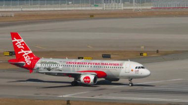 HONG KONG - 28 Ocak 2025: Airbus A320, AirAsia Universiti Putra Malaysia Livery 'den 9M-AQD Chek Kap Kok havaalanı, Hong Kong, yan görüş pistinde